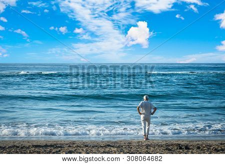 Old Man Wearing White Clothes Staring At The Sea
