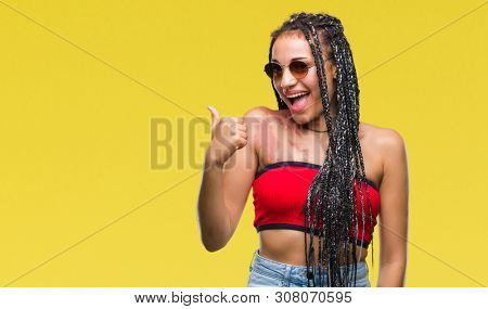 Young braided hair african american with birth mark wearing sunglasses over isolated background doing happy thumbs up gesture with hand. Approving expression looking at the camera