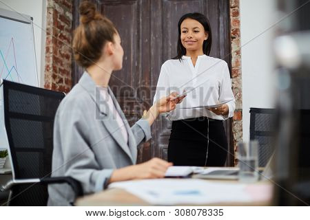 Portrait Of Smiling Mixed-race Businesswoman Bringing Documents To Female Boss, Copy Space
