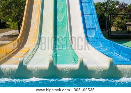 Multicolored Water Slides In Amusement Aqua Park Outdoors Sunny Summer Day