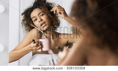 Afro-american Girl In Hurry Put On Makeup, Drinking Coffee And Talking By Phone Simultaneously In Fr