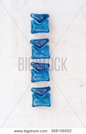 Set Of Blue Washing Detergent Capsule Isolated On White Wooden Background. Close-up.liquid Soap.