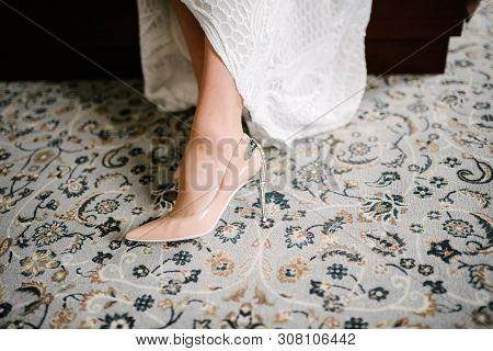 The Legs Of The Bride In A Wedding Dress In Shoes Close Op