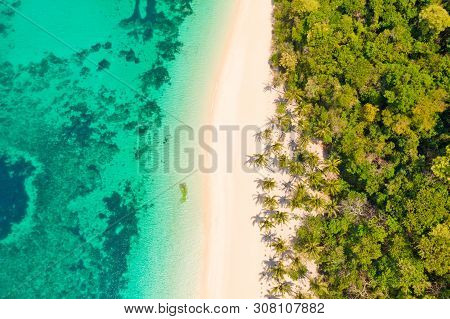Turquoise Lagoon With A Coral Reef And White Beach. Beach With White Sand And Palm Trees, View From 