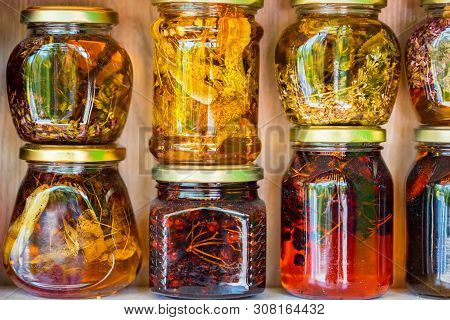 Jars With Honey And Natural Colorful Herbs For Sale On Shelves