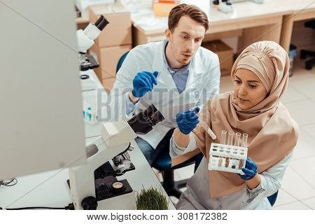 Smart Muslim Woman Looking At Test Tubes