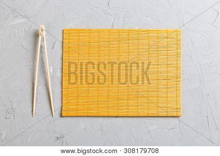 Two Sushi Training Sticks With Empty Bamboo Mat Or Wood Plate On Stone Background Top View With Copy