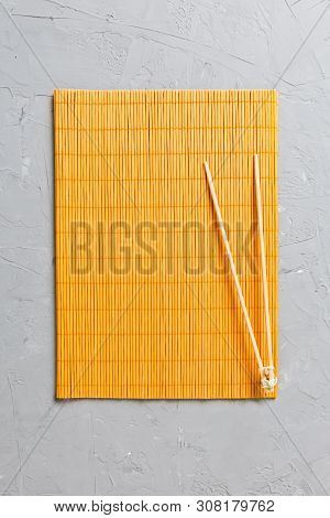 Two Sushi Training Sticks With Empty Bamboo Mat Or Wood Plate On Stone Background Top View With Copy