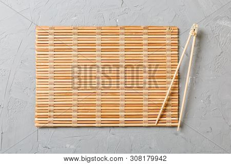 Two Sushi Training Sticks With Empty Bamboo Mat Or Wood Plate On Stone Background Top View With Copy