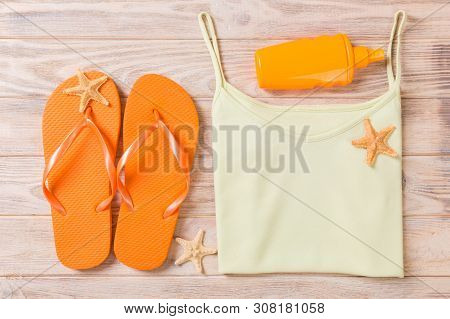 Summer Accessories With T-shirt, Seashells And Flip Fops On Wooden Background Top View Flat Lay