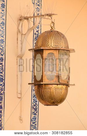 Udaipur, Rajasthan / India - 25 June 2019: Abstract Background Of Gold Vintage Lamp Hanging On Wall 