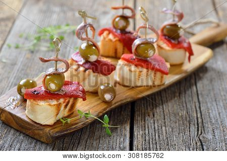 Spanish Pinchos: Skewer Snacks Made Of Grilled Bread With Roasted And Pickled Peppers, Olives Stuffe