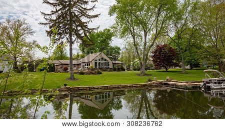 Spring Day In Canton, Ohio, Usa. A Boat In The Water, Green Grass And Trees