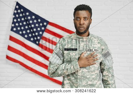 Front View Of Male American Soldier Holding Hand On Heart And Seriously Looking At Camera. Ranker In