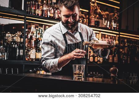 Diligent Happy Barman Is Preparing Alcoholic Beverege For Customer.