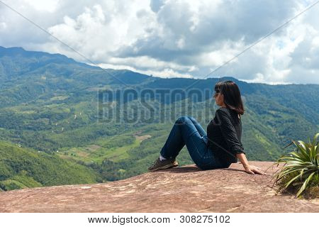 Tourist Woman Sits On A Cliff Edge On The Top Of Mountain With Gorgeous View At Stunning Valley In T