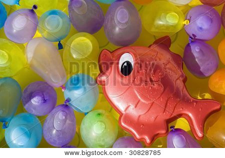 ปลาของเล่นสีแดงระหว่าง Ballons สี