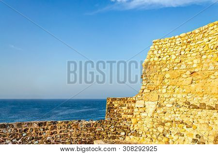 Old, Abandoned And Ruined Fort Wall Opening To The Blue Sea With Clear Sky. From Muttrah, Muscat, Om