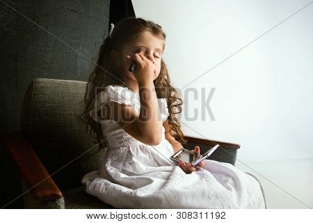 Interaction Of Children With Adult World. Cute Girl Trying To Do Bright Make Up For Being Older. Lit