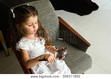 Interaction Of Children With Adult World. Cute Girl Trying To Do Bright Make Up For Being Older. Lit