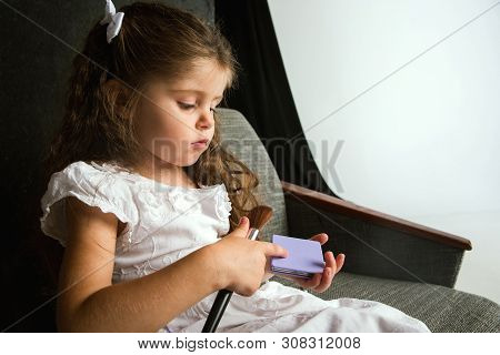 Interaction Of Children With Adult World. Cute Girl Trying To Do Bright Make Up For Being Older. Lit