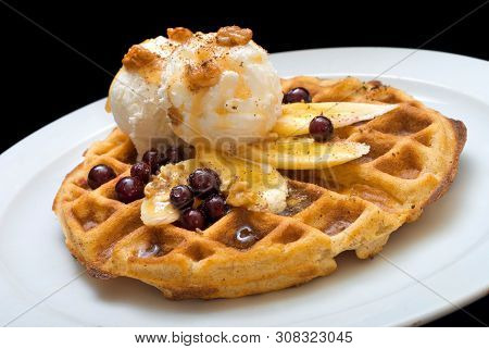 Gofre - Belgian Homemade Waffles With Ice Cream, Bananas And Nuts On A White Plate