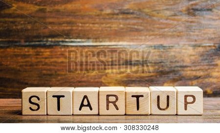 Wooden Blocks With The Word Startup. Temporary Structure Designed To Find And Implement A Scalable B