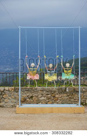 Mougins, France - April 03, 2019: Art Installation Three Girls On Swings