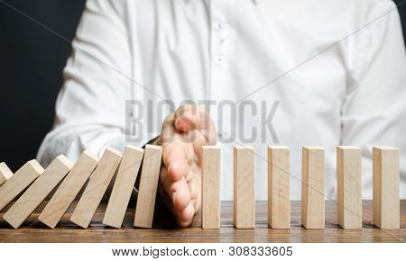 Businessman Stops Domino Falling. Risk Management Concept. Successful Strong Business And Problem So