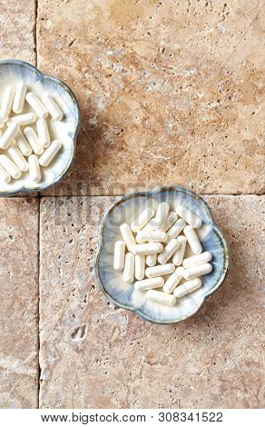 Theanine Capsules. Dietary Supplement.  Bright Stone Background. Top View. Copy Space.