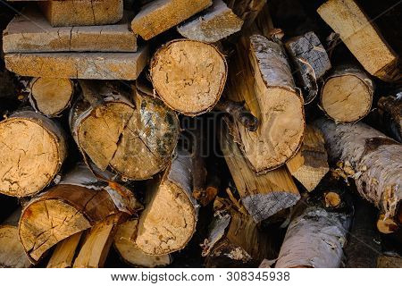 Natural Wooden Background Closeup Of Chopped Firewood. Firewood Stacked And Prepared For Winter Pile