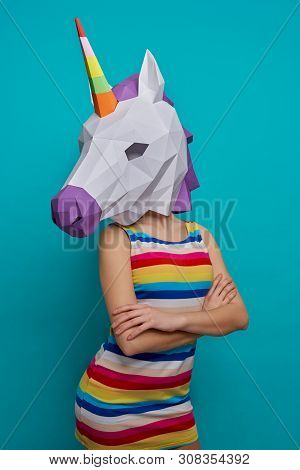 Slender, Stylish Model Posing With Paper 3d Unicorn On Head On Blue Background. Graceful Girl In Str
