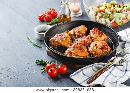 Chicken Thighs Fried With Rosemary In A Cast Iron Skillet And Green Salad With Cherry Tomatoes, Feta