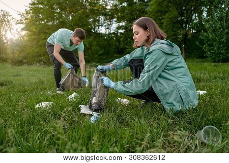 Friends Crouching With Bag Picking Up Trash Doing Plogging.plogging Concept. Boy And Girl Picking Up