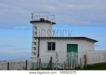 Whitewashed Coastguard Station Found Above The Irish Sea In England.