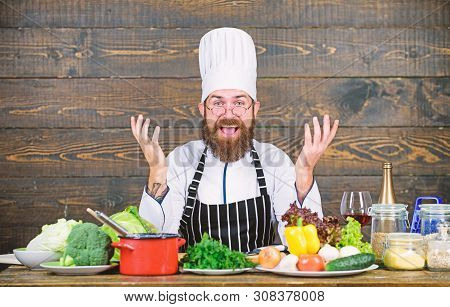 Happy Bearded Man Cooking In Kitchen. Dieting With Organic Food. Fresh Vegetables. Vitamin. Man Use 