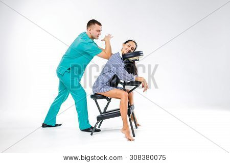 Theme Massage And Office. Male Therapist With Blue Suit Doing Back And Neck Massage For Young Woman 
