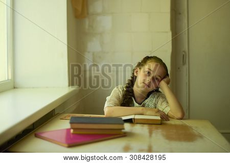 Pupil In School Uniform With Braids. Girl Schoolgirl At School With Book In School Uniform. Training