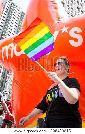 2018 JUNE 24 NEW YORK: NYC Pride March participants hold the Macys Pride and Joy balloons on the 5th Ave parade route.