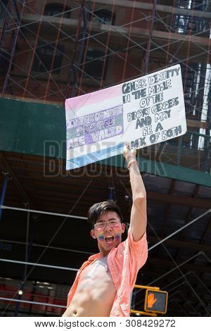 2018 JUNE 24 NEW YORK: NYC Pride March participant holds a sign that says InterGender People Are Valid on the 5th Ave parade route.
