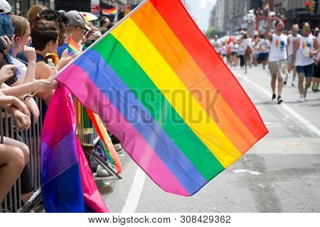 2018 JUNE 24 NEW YORK: NYC Pride March spectators wave rainbow flags and cheer the participants at 23rd St and 5th Ave.
