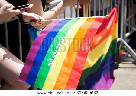2018 JUNE 24 NEW YORK: NYC Pride March spectator waves a rainbow flag with Planned Parenthood written on it and cheer the participants at 23rd St and 5th Ave.