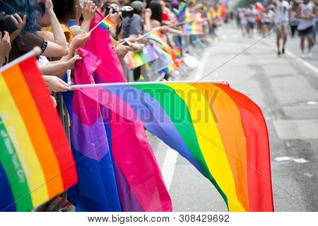 2018 JUNE 24 NEW YORK: NYC Pride March spectators wave rainbow flags and cheer the participants at 23rd St and 5th Ave.