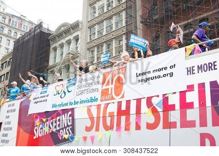2018 JUNE 24 NEW YORK: NYC Pride March participants riding on the SAGE float  wave to cheering spectators along the 5th Ave parade route.