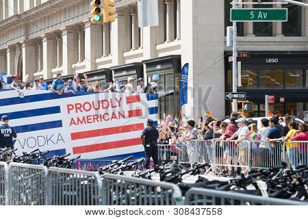 2018 JUNE 24 NEW YORK: NYC Pride March participants ride on the top deck of the SKYY Vodka Proudly American float on the 5th Ave parade route.
