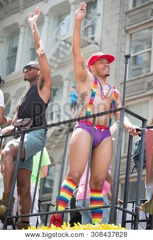2018 JUNE 24 NEW YORK: NYC Pride March participants wave to cheering spectators from the top of the KTU 103.5 FM float on the 5th Ave parade route.