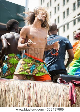 2018 JUNE 24 NEW YORK: NYC Pride March participant dances while riding on a parade float along the 5th Ave route.