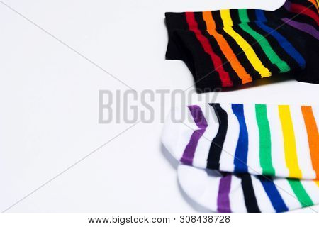 Two Pair Of Black And White Textile Cotton Socks With Striped Bright Colorful Pattern Over White Bac