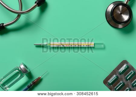 Mercury Thermometer At  40 Degrees Centigrade With Syringe And Vaccine And Stethoscope And Capsules 