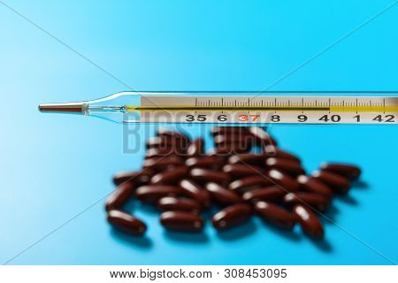 Mercury Thermometer At  40 Degrees Centigrade With Dozens Capsules At Background